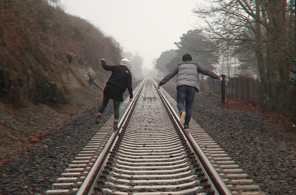 two people walking on a traintrack